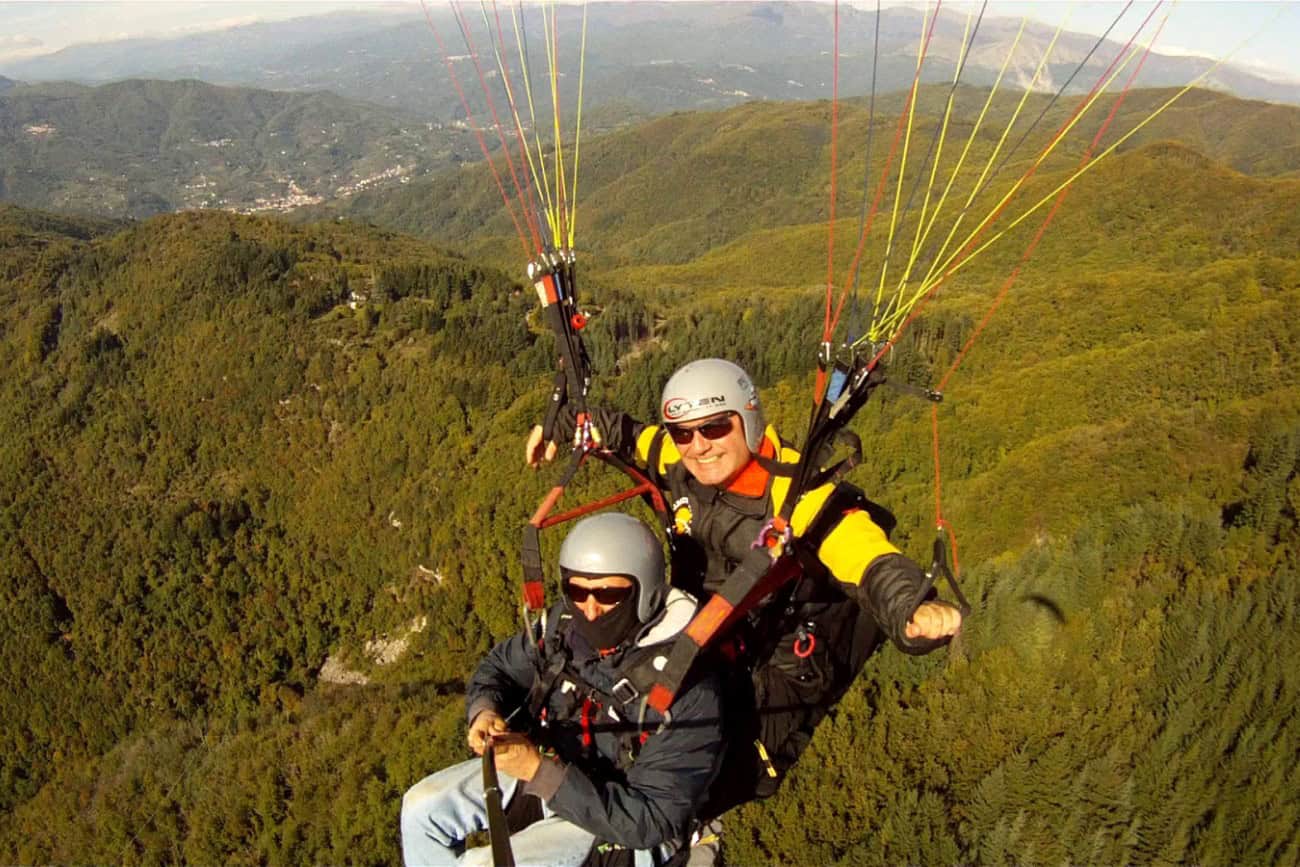 Volo in parapendio sopra le colline boscose della Val di Lima