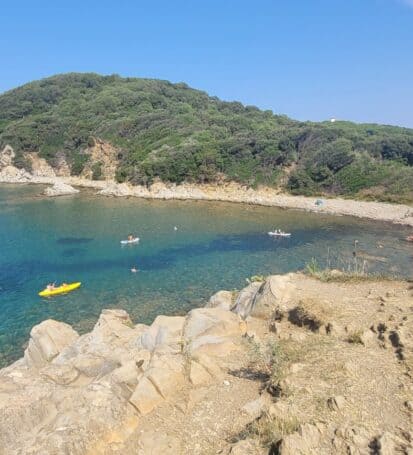 Vista aerea del Pozzino a Baratti sulla Costa degli Etruschi con bagnanti e kayak