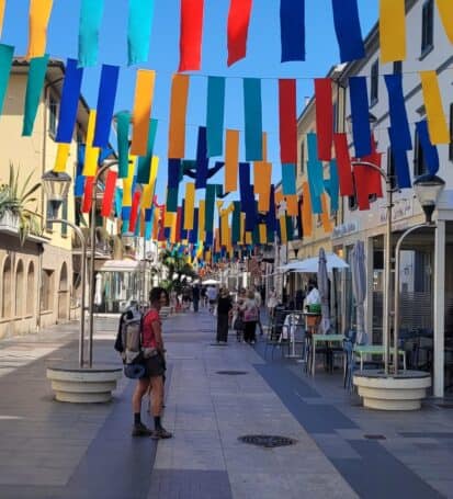 Via pedonale colorata nel centro di San Vincenzo con bandierine e negozi per il carnevale del mare