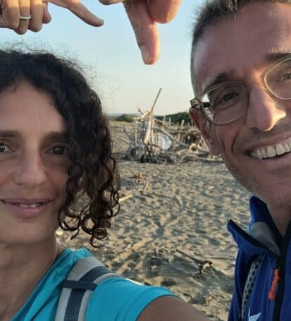 Coppia sorridente che fa un selfie sulla spiaggia durante il trekking sulla Costa degli Etruschi